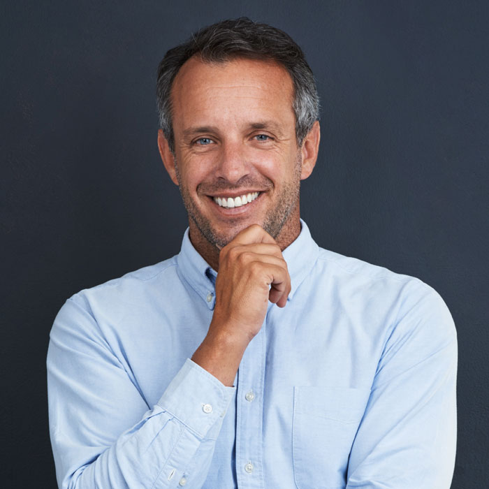 mature man smiling with hand on chin