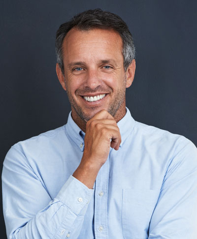 mature man smiling with hand on chin