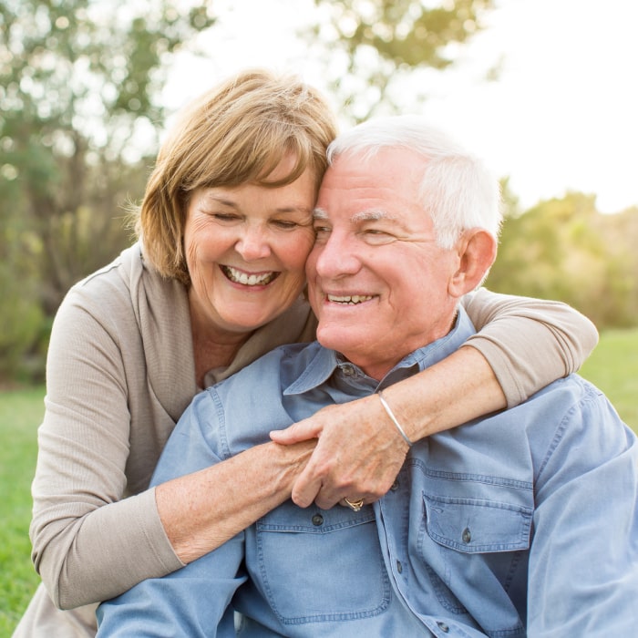 Elderly couple embracing outside